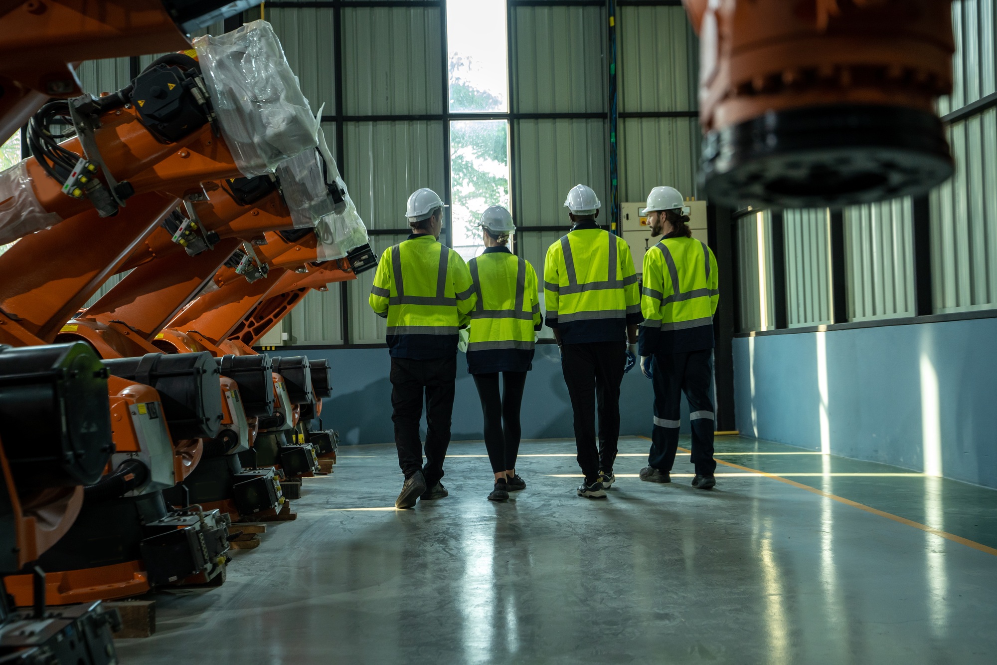 Robotics engineers inspect and maintain spare parts of industrial robot arm.